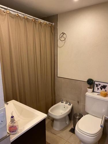 a bathroom with a white toilet and a sink at Departamento Rincon Pinamar in Pinamar