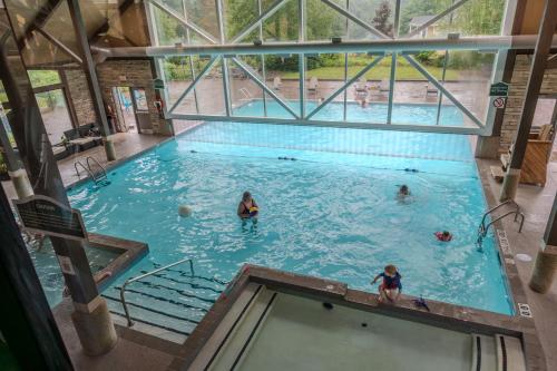 King Bed, Balcony, Pool, Hot Tub, Sauna في Edgar: مسبح كبير مع وجود ناس في الماء