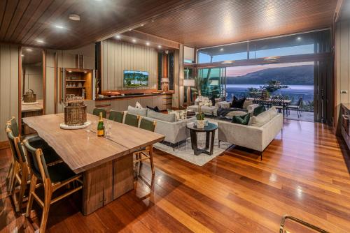a living room with a dining table and a living room at Yacht Club 33 Serenity House Ocean Views 2 Buggies in Hamilton Island