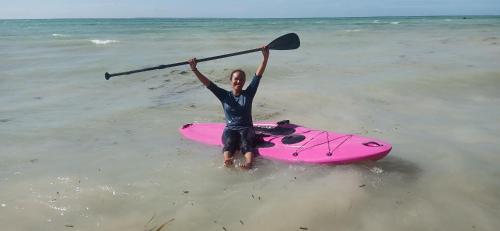 a man holding a paddle on a pink kayak in the ocean at Bermuda Beach Aquatica in Daanbantayan