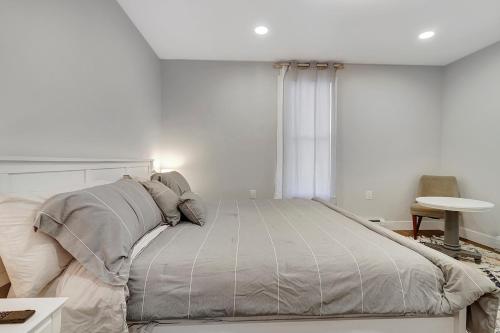 a white bedroom with a large bed with pillows at Spacious Central 4BR, Ski & Bike in Rutland
