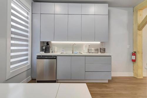 a kitchen with white cabinets and stainless steel appliances at Spacious Central 4BR, Ski & Bike in Rutland