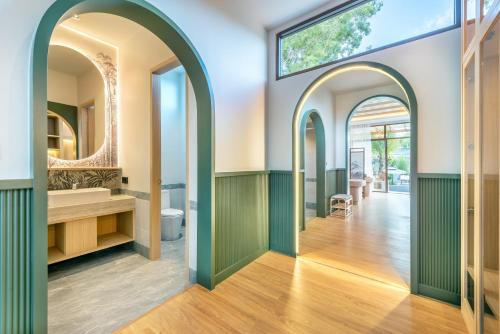 ein Badezimmer mit grünen und weißen Wänden und Bögen in der Unterkunft AZ Sunrise Resort & Fitness Club in Layan Beach