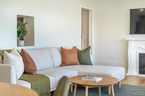 a living room with a couch and a coffee table at Luxury Beachfront Apartment - Private Lower Suite in Wellington