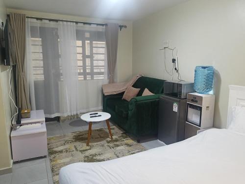 a living room with a green couch and a table at Legatus Cozy Studios Ngong in Ngong