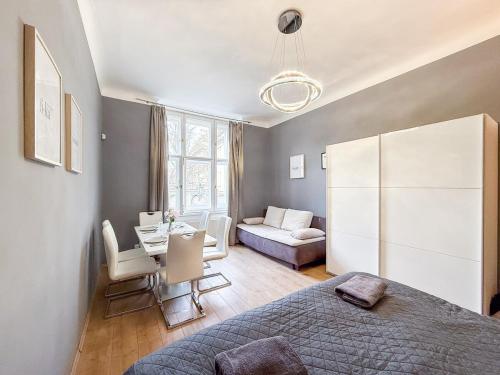 ein Schlafzimmer mit einem Bett, einem Tisch und einer Couch in der Unterkunft Josefov Riverside Apartment in Prag