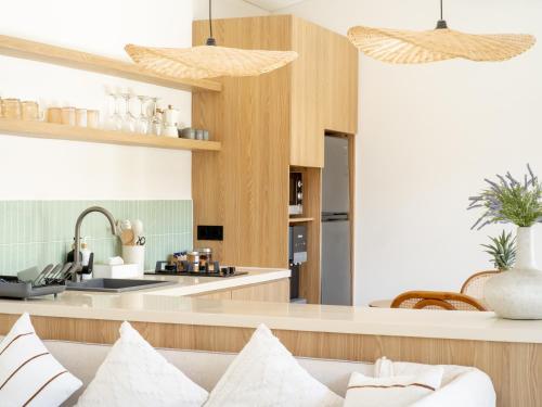 a living room with a couch and a kitchen at Aquae Villas - Lavanda - Chic Villa 2 bdr - pool - Kuta Lombok in Kuta Lombok