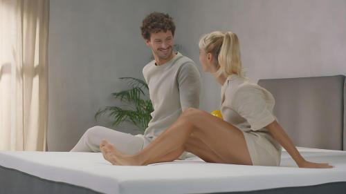 a man and woman sitting on a bed at Agile TRX Luxury Condo in Bukit Bintang in Kuala Lumpur