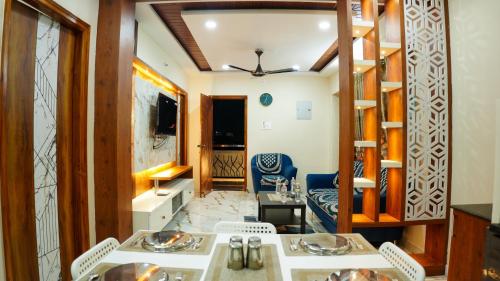 a room with two tables and chairs and a living room at Urban Nest Homestay in Tirupati