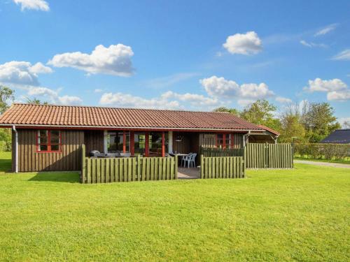 a small house with a fence in a yard at 5 person holiday home in Tarm in Tarm