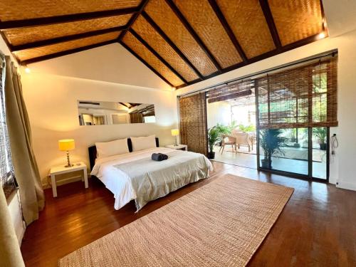 ナ・ジョムティエンにあるNatural Villas - Baan Somprasongのベッドと大きな窓のある寝室