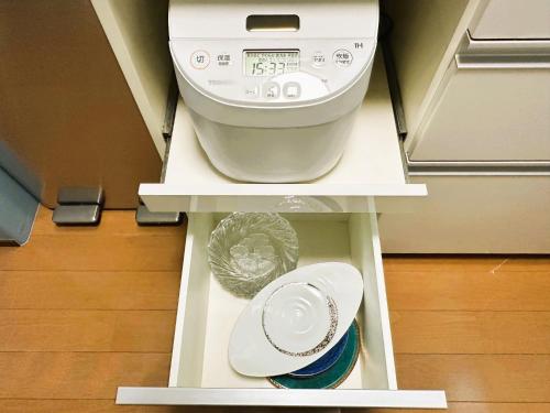 a washing machine on a shelf in a room at 一組貸切の戸建民泊旅館 熊本熊猫基地 新町 Kumamoto Panda Base Shinmachi in Kumamoto