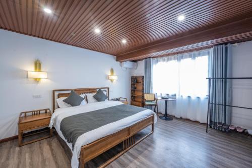 a bedroom with a large bed with a wooden ceiling at The Lu Village Retreat in Guilin