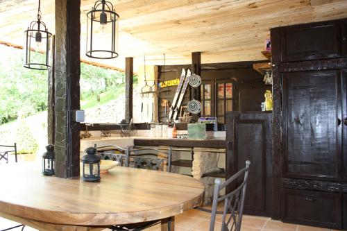 une salle à manger avec une table en bois et une cuisine dans l'établissement Le Coustal, à Auriac-du-Périgord