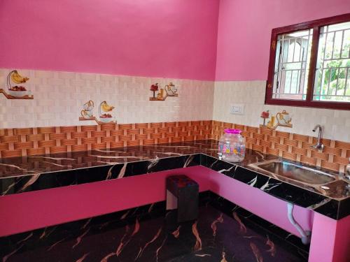 cocina rosa con fregadero y encimera en Isakki Cottage, en Tiruchchendūr
