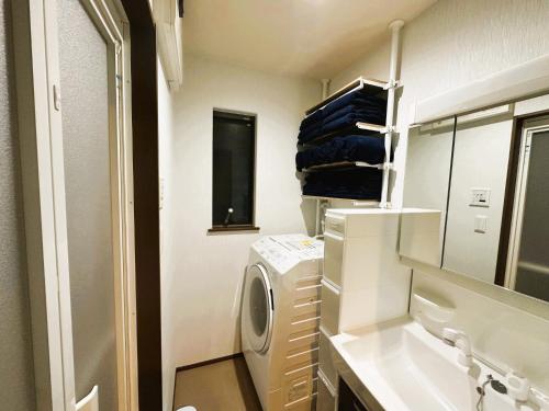 a laundry room with a washing machine and a mirror at 一組貸切の戸建民泊旅館 熊本熊猫基地 新町 Kumamoto Panda Base Shinmachi in Kumamoto