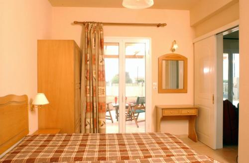 Almiros BeachにあるVilla Filia stdのベッドルーム1室(ベッド1台付)、パティオへのドアが備わります。