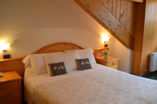 a bedroom with a bed with two pillows on it at Albergo La Bicocca in Paneveggio