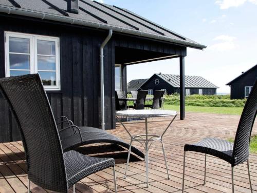a group of chairs and a table on a deck at 8 person holiday home in Nysted-By Traum in Nysted