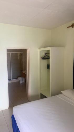 a bedroom with a bed and a bathroom with a toilet at Fun Holiday Beach Hotel in Negril