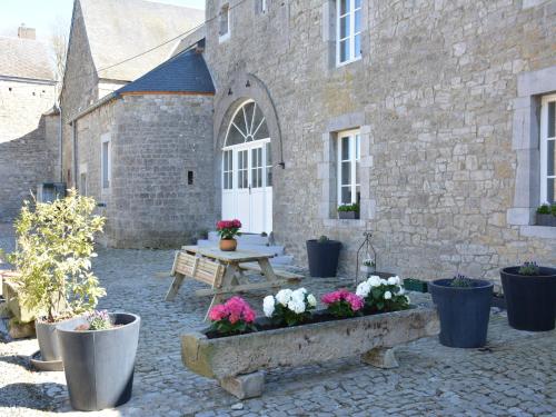 a courtyard with a table and flowers in front of a building at Charming Farmhouse in Ouffet for 7 in Ouffet