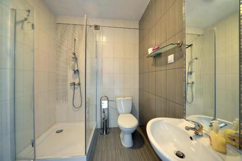 a bathroom with a toilet and a sink and a shower at JD Apartamenty - Klimatyzacja, basen, parking i wifi w cenie in Mysłakowice