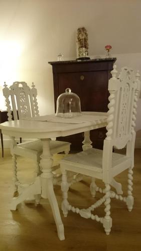 - une table blanche avec une bouilloire et 2 chaises dans l'établissement Chateau Des Roises, à Bucey-en-Othe