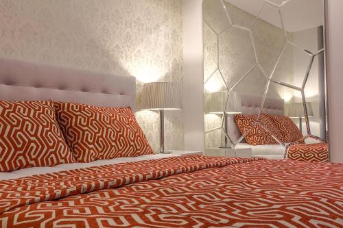 1 dormitorio con 1 cama grande con almohadas de color rojo y naranja en Bracara Guest House "Arcada", en Braga