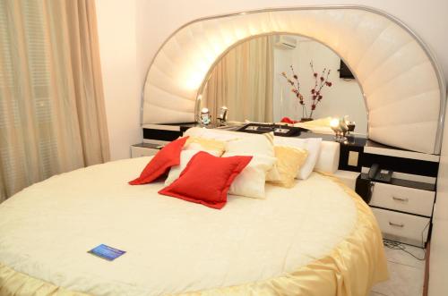 1 dormitorio con 1 cama blanca grande y espejo grande en Fares Turis Hotel en Uruguaiana