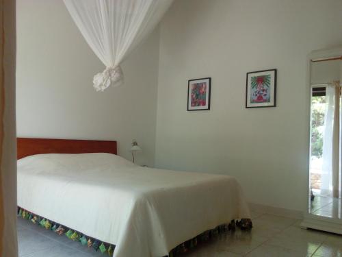 une chambre blanche avec un lit et une fenêtre dans l'établissement Le Paradis de Valérie, à Sète