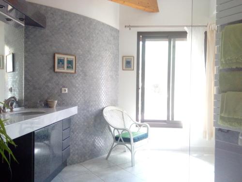- une cuisine avec une chaise et un évier dans l'établissement Le Paradis de Valérie, à Sète