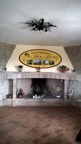 a living room with a fireplace with a sign above it at Agriturismo La Vite e L'Ulivo in Baschi