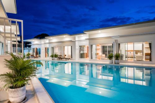 a villa with a swimming pool at night at SALA Villa Pranburi in Ban Khao Noi