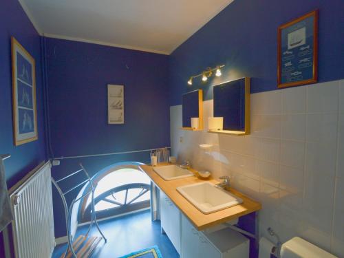 a bathroom with two sinks and a blue wall at Elegant Castle Stay, Havelange in Barvaux-Condroz