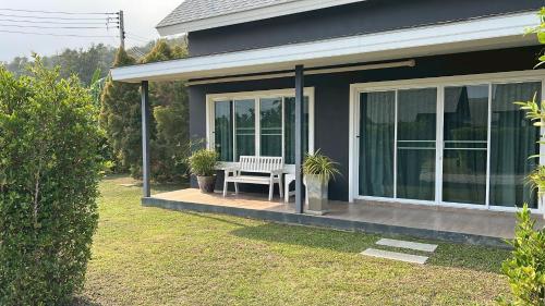 a house with a white bench on a porch at The Barn Hua Hin in Khao Tao