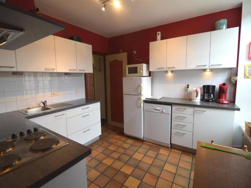 a kitchen with white appliances and red walls at Elegant Castle Stay, Havelange in Barvaux-Condroz