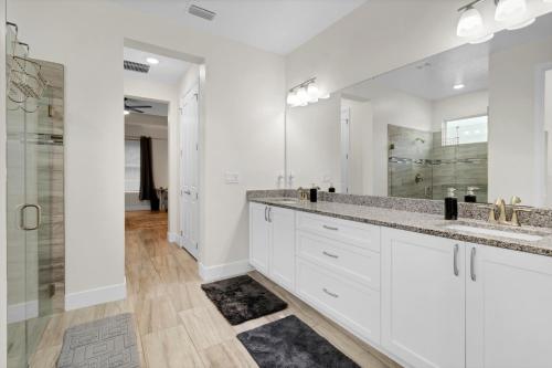 a bathroom with two sinks and a shower at Spacious Suite in modern house in Orlando