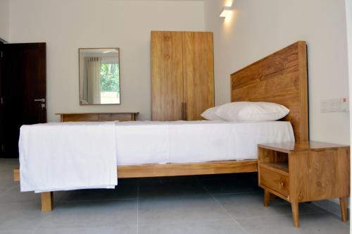 a bedroom with a large bed and a table at Bolgoda Water Estate Villa By CM Holiday in Panadura