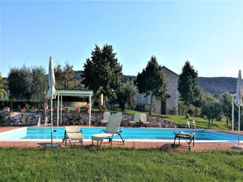 a swimming pool with two chairs and a table at Montalceto Tuscan Nest in Serre di Rapolano