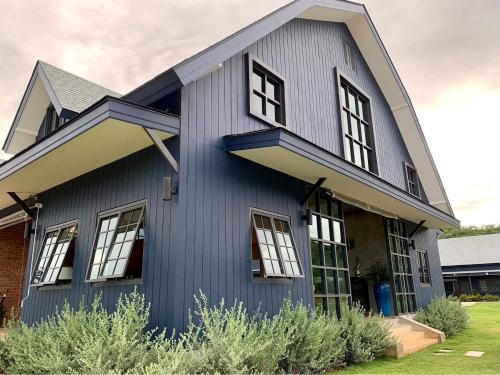 a blue house with windows on the side of it at The Barn Hua Hin in Khao Tao