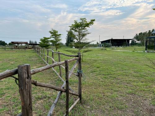 a wooden fence in the middle of a field at The Barn Hua Hin in Khao Tao