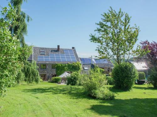 a house with solar panels on top of a yard at Desnié Farmhouse with Pool in Desnié