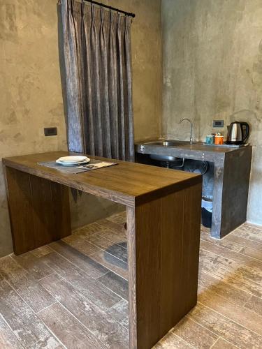a kitchen with a wooden table and a sink at The Barn Hua Hin in Khao Tao