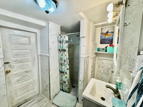 a bathroom with a shower and a sink at Cozy Private Room with Shared Bathroom on the 1st Floor - Conveniently Located near SeaTac Airport and Downtown in Seattle