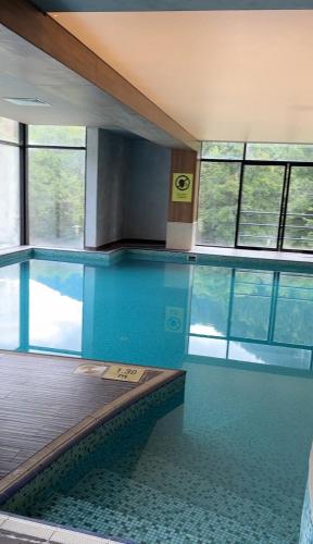 a swimming pool with blue water in a building at Luxury Residence Likani in Borjomi