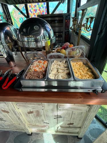 a table with several trays of food on it at SaguleResort in Monasteri