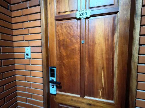 a wooden door with a sign on it at Dalat Note Hostel in Da Lat