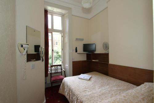 a room with a bed and a phone in it at Ridgemount Hotel in London