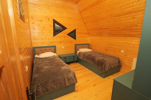 a room with two beds in a log cabin at SaguleResort in Monasteri