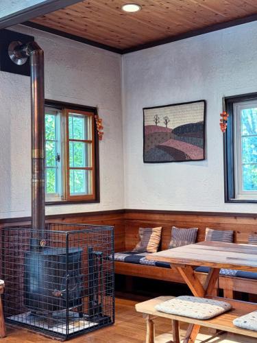 a room with a couch and a fireplace and a table at Ringo Lodge Hakuba in Hakuba